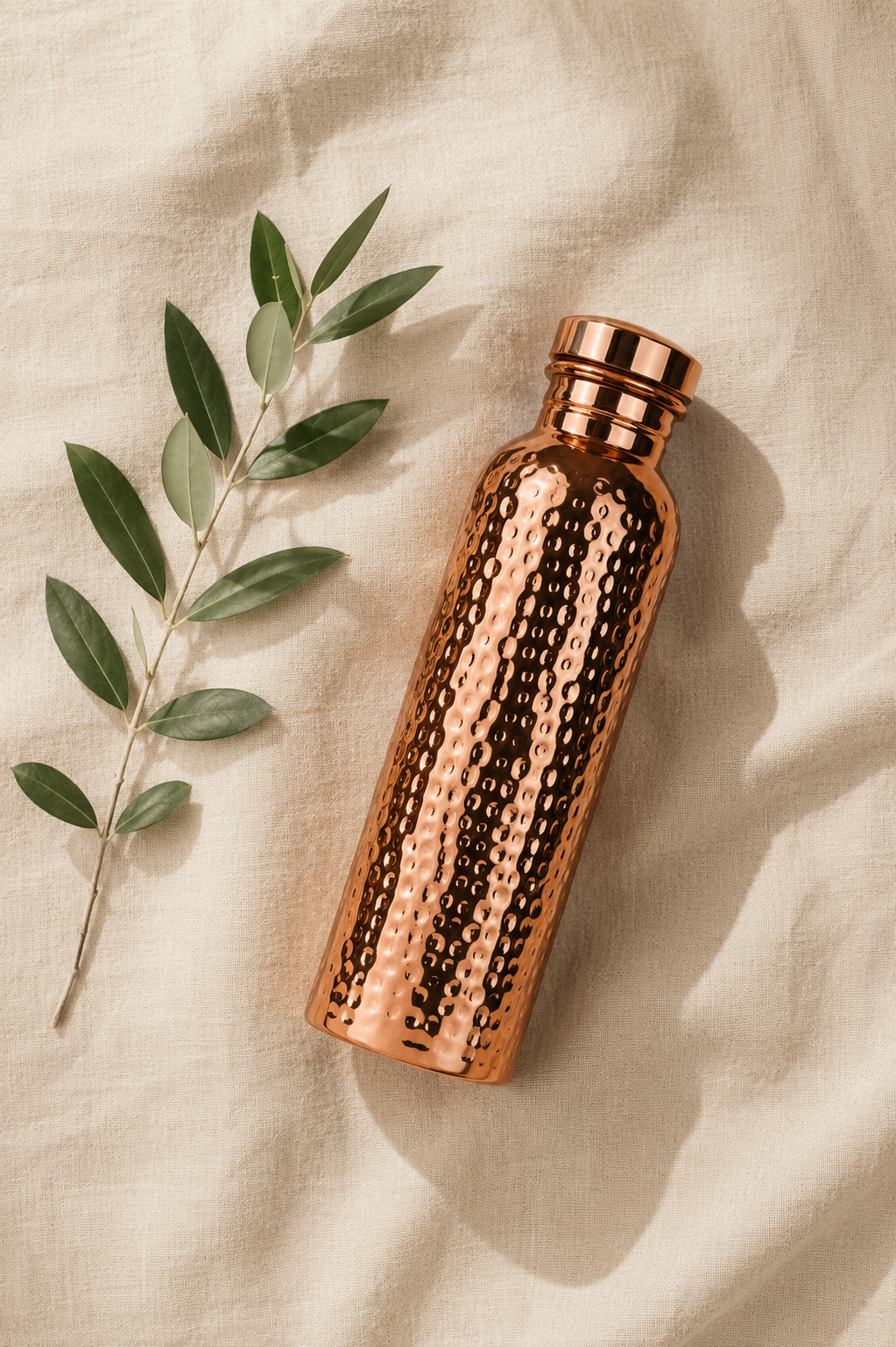 Overhead flat lay of the Copper Ritual bottle with a eucalyptus sprig