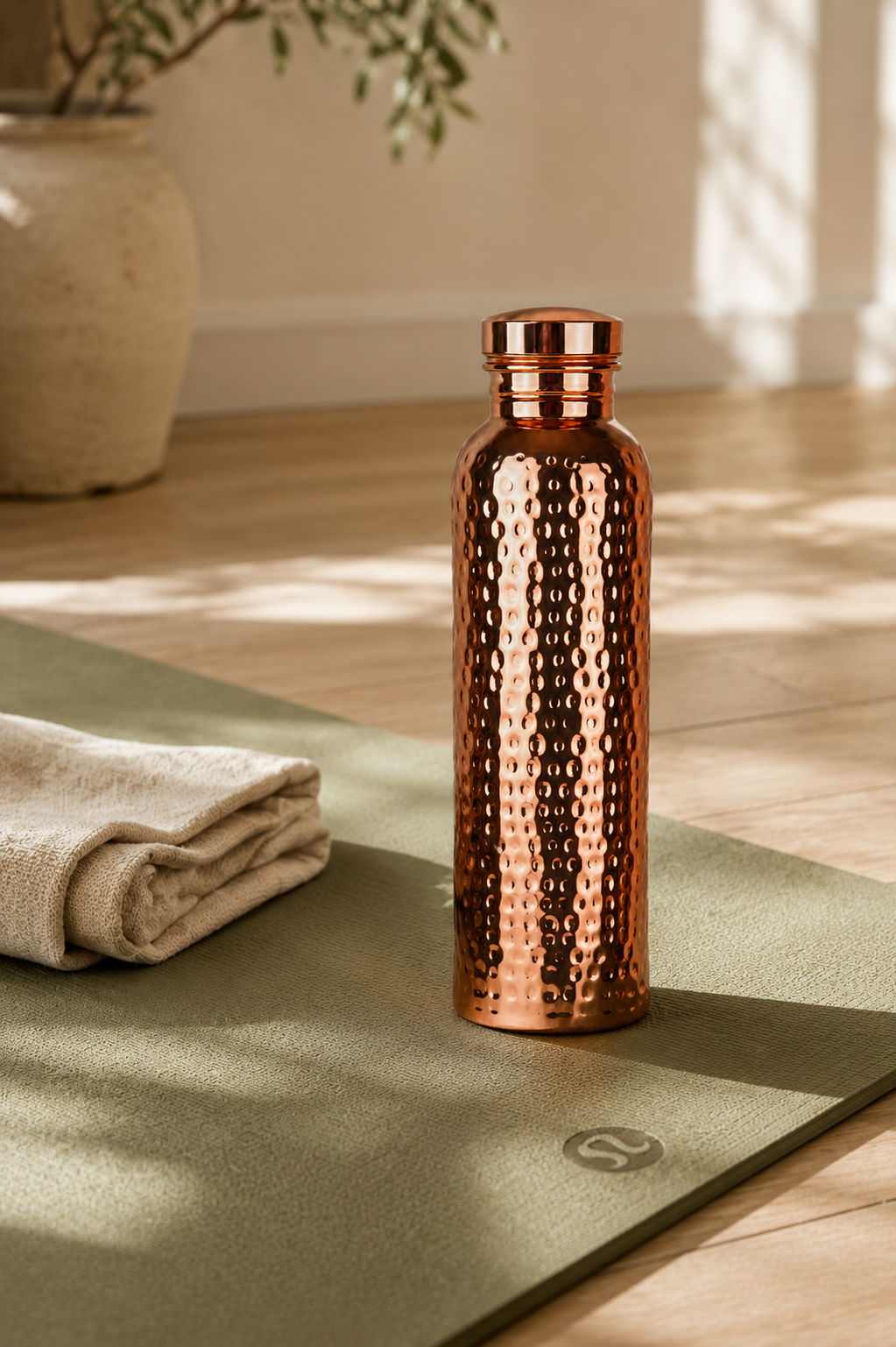 Copper Ritual bottle on a yoga mat with a folded linen towel